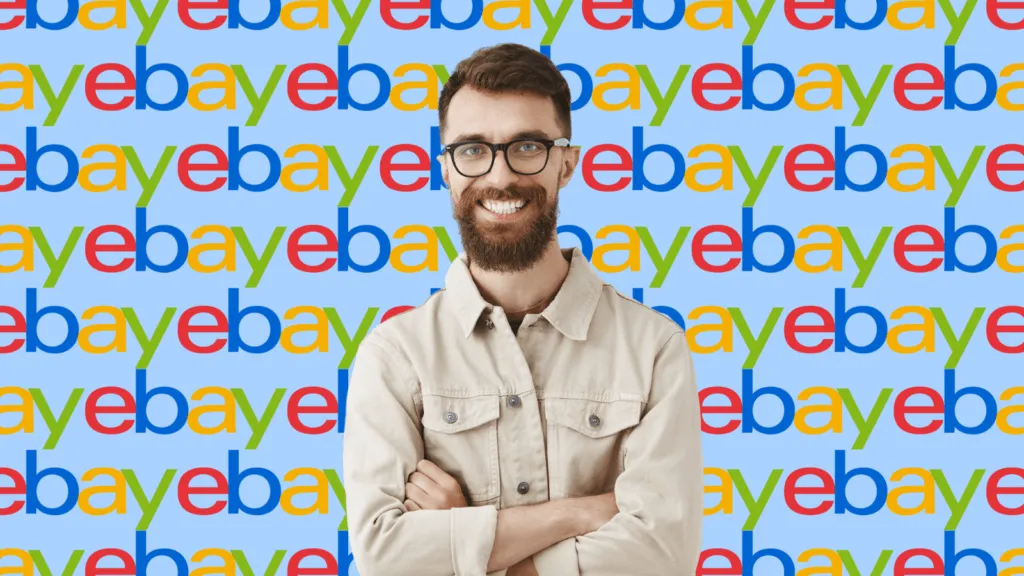 A young professional man in glasses smiles in front of a background made of eBay logos.